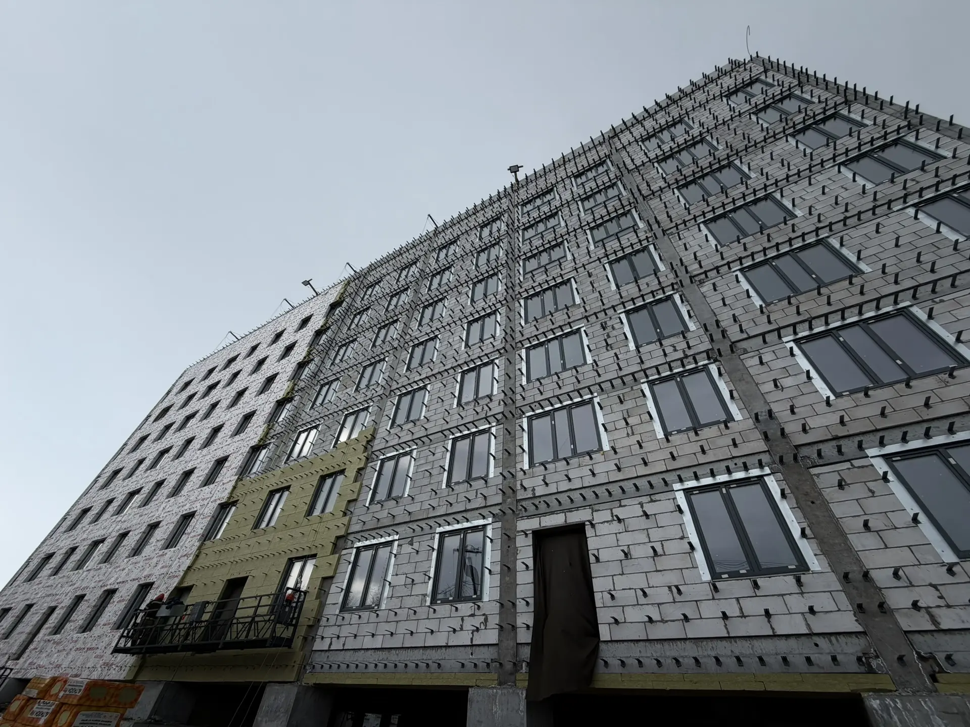 Строители приступитили к утеплению фасада строящегося дома в Салехарде Строители приступитили к утеплению фасада строящегося дома в Салехарде